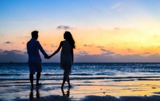 couple holding hands at the beach to illustrate Vows for Eternity Matchmaking