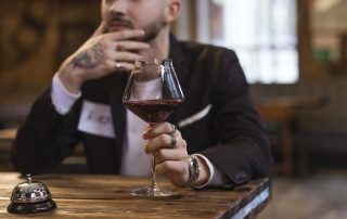 man holding wine glass on a speed date to illustrate corona-safe speed dating