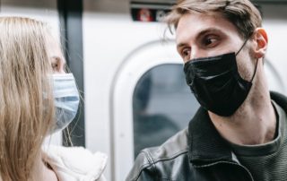 couples on the subway wearing face masks to illustrate pandemic relationships