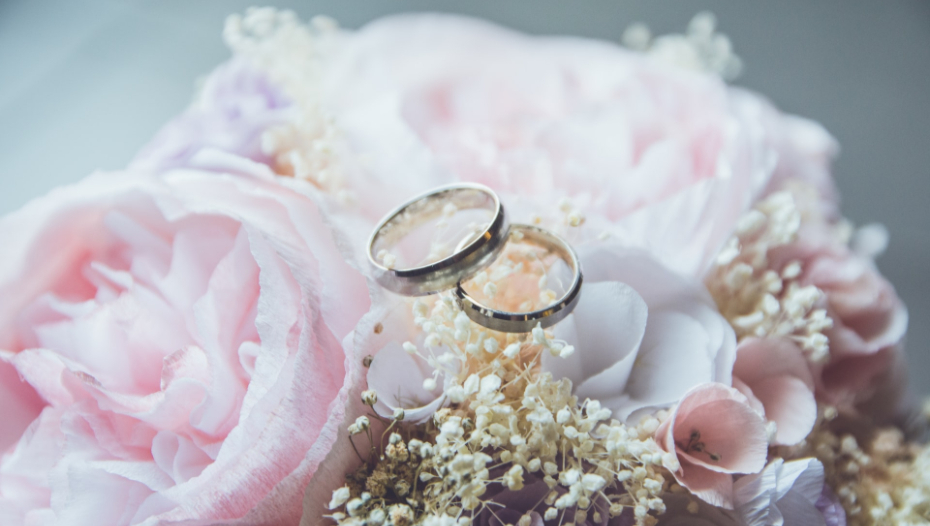 wedding rings on top of a bouquet to illustrate Covid marriages