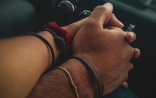 couple holding hands in a car to illustrate car speed dating