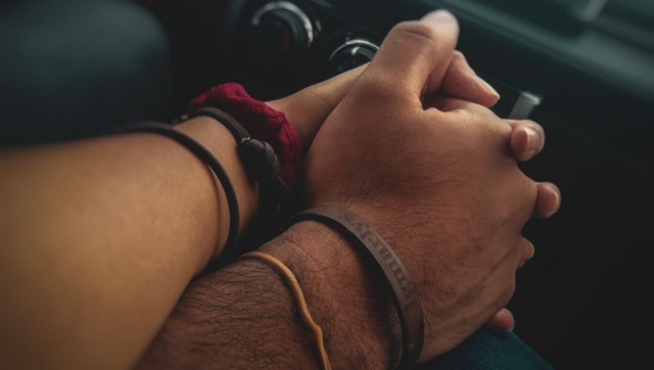 couple holding hands in a car to illustrate car speed dating