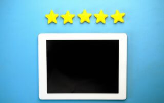 Tablet with five yellow stars on a blue background, ideal for rating concepts.