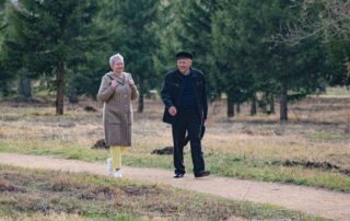 Happy senior couple strolling along a park path on a pleasant spring day.