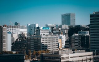Aerial view of Tokyo's modern skyline features towering buildings and urban architecture under a clear blue sky.
