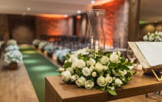 A close-up of a beautiful white rose arrangement at an indoor wedding venue.