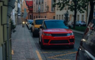 Street view in a city with parked cars, highlighting urban architecture and lifestyle.