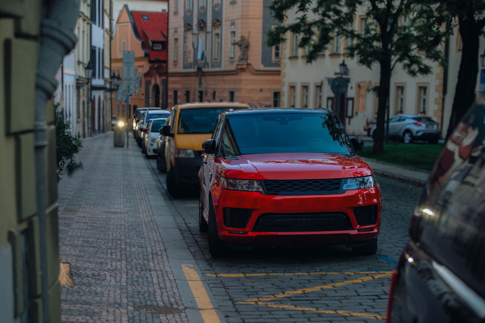 Street view in a city with parked cars, highlighting urban architecture and lifestyle.