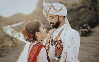 Beautiful Indian couple embraces during an outdoor wedding ceremony, showcasing traditional attire and love.