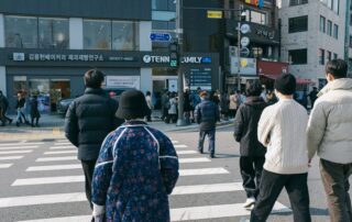 People crossing a bustling street in Seoul, South Korea, on a bright day, showcasing urban life.