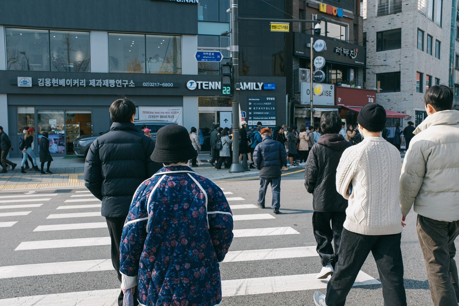 People crossing a bustling street in Seoul, South Korea, on a bright day, showcasing urban life.