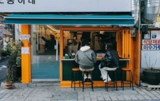 A couple sitting at a cozy street café in Seoul, South Korea, enjoying the urban atmosphere.