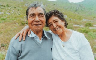 Smiling senior couple embracing in a scenic outdoor setting, expressing love and happiness.