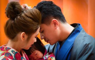 A heartfelt moment between parents and child wearing colorful traditional kimonos.