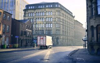 A quiet urban street scene with historic architecture in early morning light.