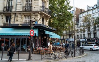 A scenic Paris café on a cobblestone street corner, capturing classic architecture and local life.