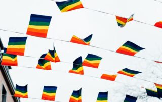Vibrant rainbow pride flags fluttering outdoors under a bright sky, symbolizing LGBTQ+ equality.
