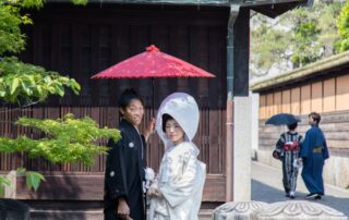 Elegant Japanese wedding couple in traditional attire with parasol in Kurashiki, Japan.
