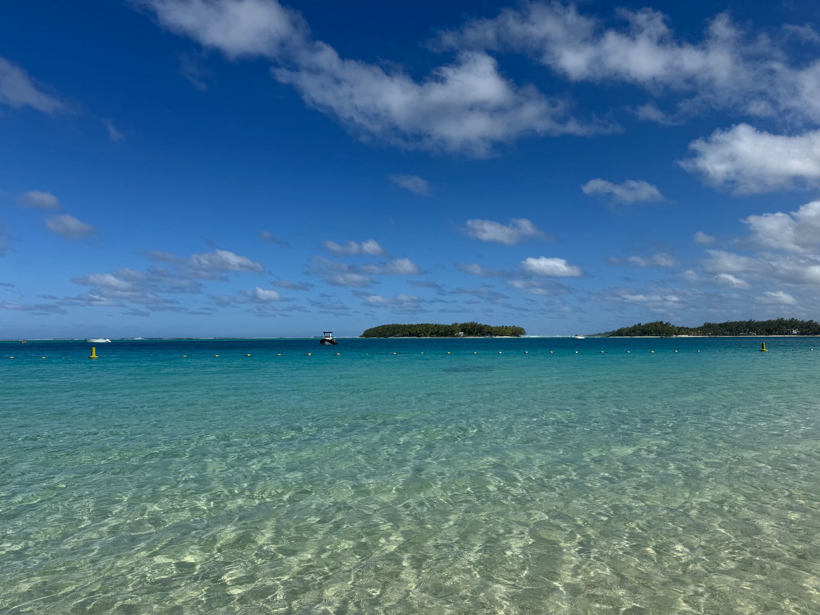 Crystal clear waters at Blue Bay, Grand Port District, Mauritius under a vibrant blue sky.