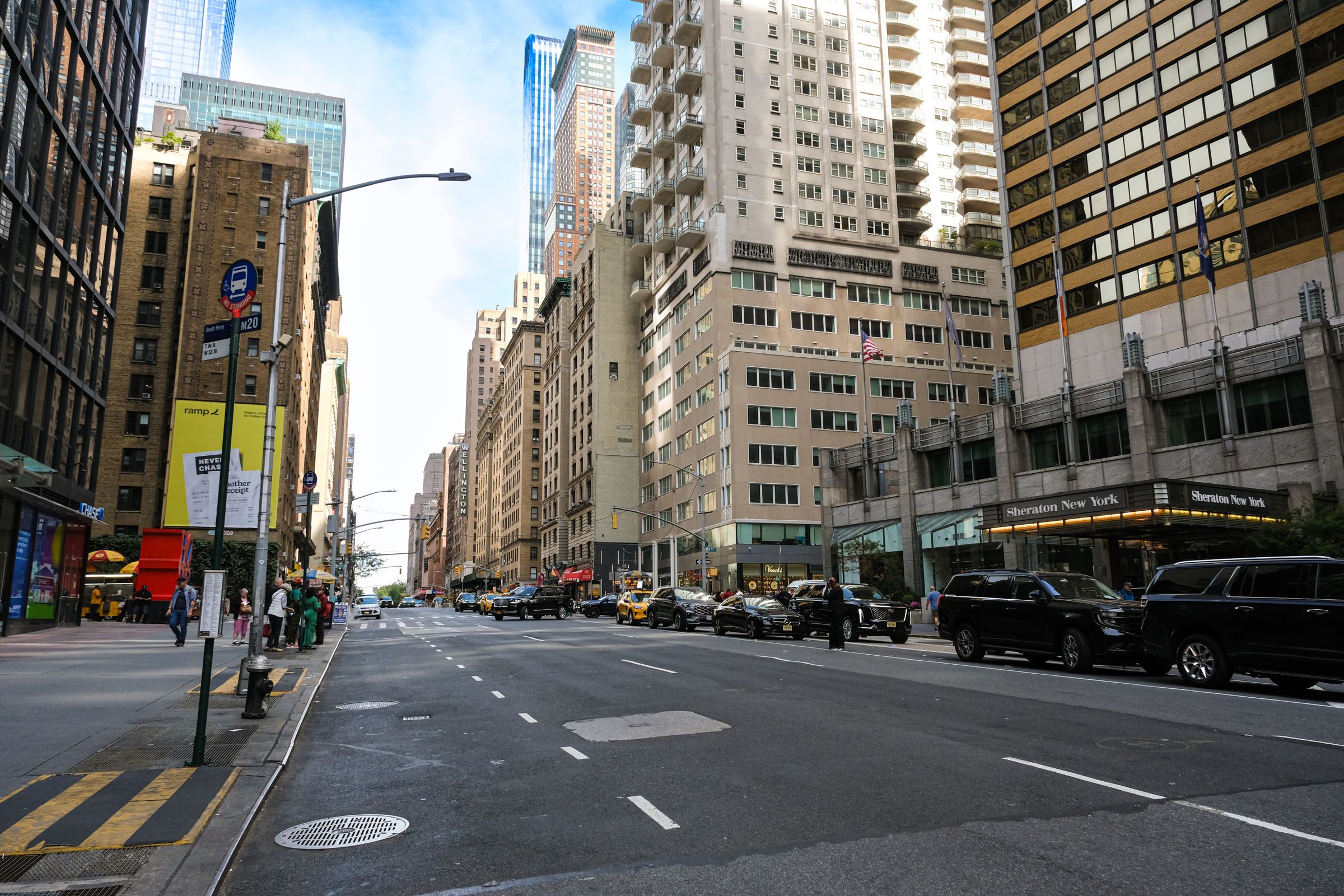 Urban cityscape of Midtown Manhattan with skyscrapers, vehicles, and pedestrians.