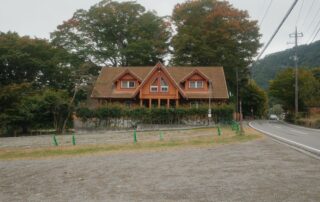 Quaint wooden house surrounded by lush greenery in Fujikawaguchiko, Yamanashi, Japan.
