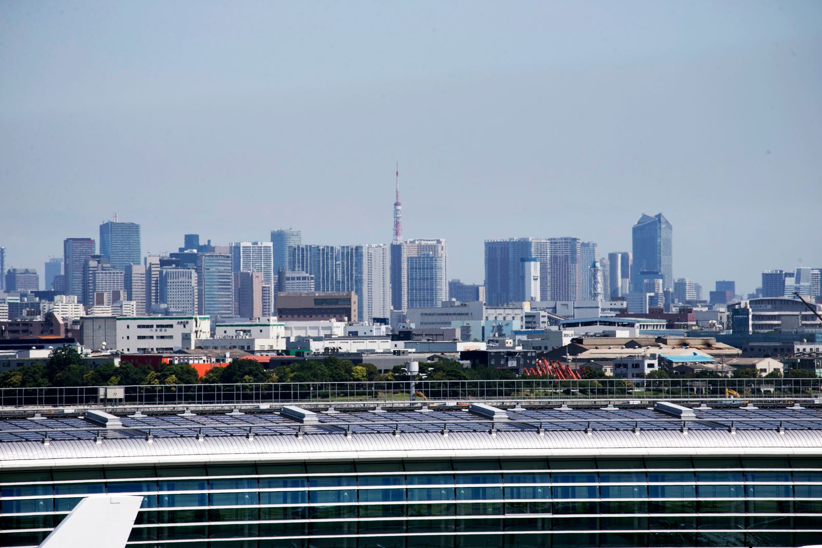 Aerial view of Tokyo skyscrapers with Tokyo Tower visible, showcasing urban architecture.