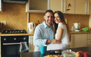 Happy couple embraces in a cozy kitchen setting, embodying warmth and positivity.