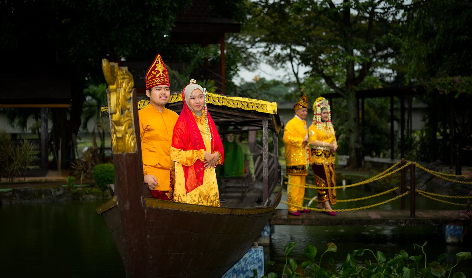 Couples in vibrant Indonesian wedding attire on a traditional wooden boat in Jakarta.