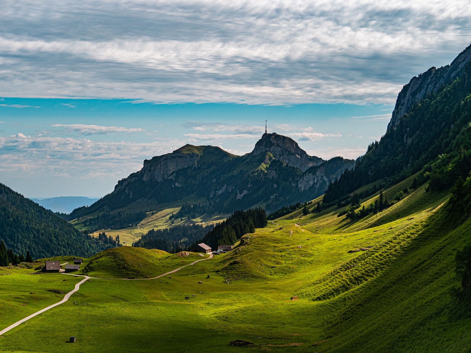 Breathtaking view of lush green valleys and mountains in Sennwald, Switzerland.