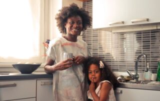 A joyful mother and daughter enjoying a morning in their home kitchen, capturing family warmth and closeness.