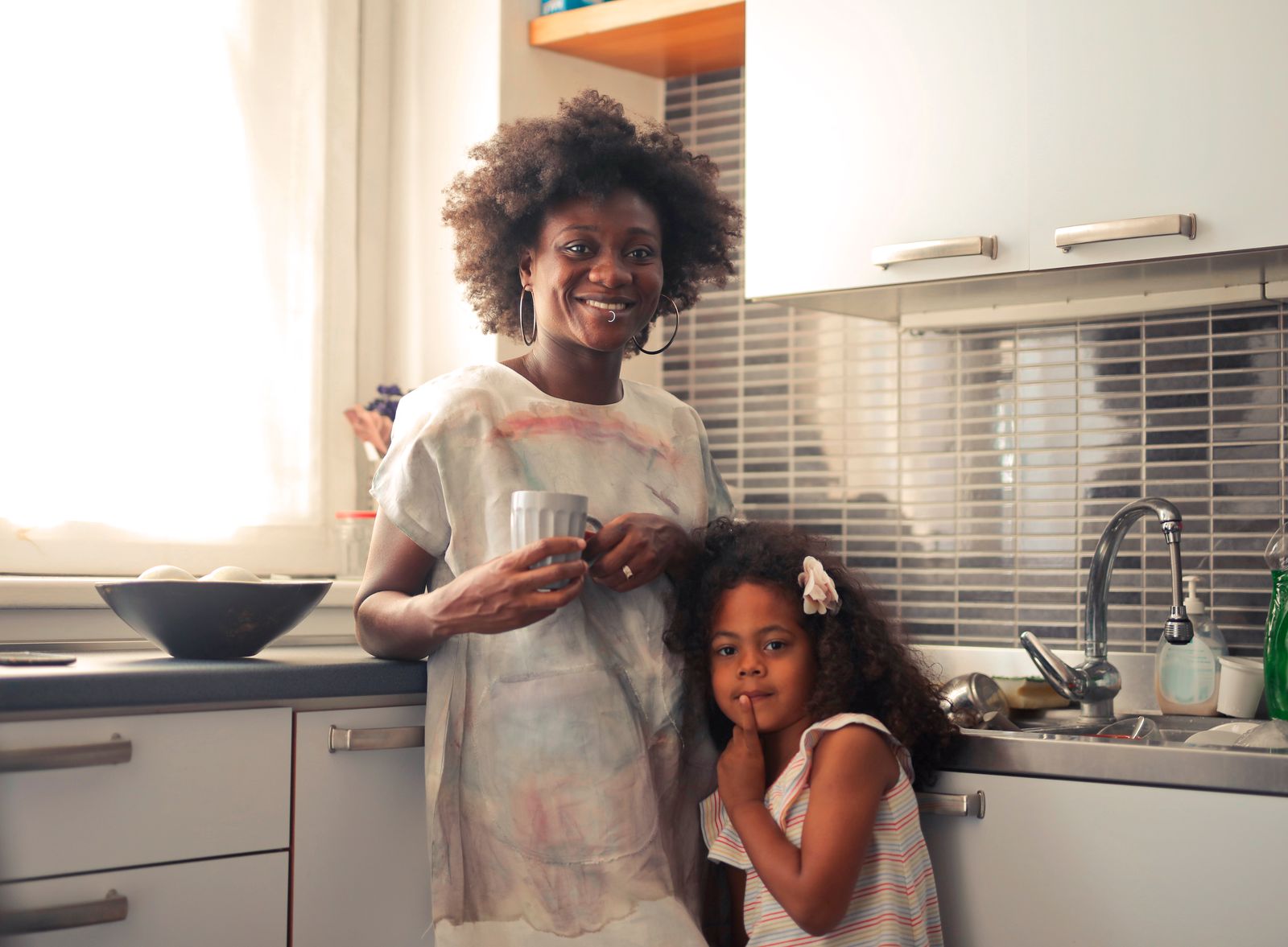 A joyful mother and daughter enjoying a morning in their home kitchen, capturing family warmth and closeness.