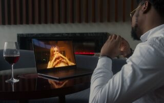 Man having a video call date with wine, enjoying a cozy and intimate atmosphere.