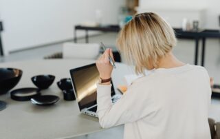 A businesswoman concentrating on her laptop in a contemporary office setting.