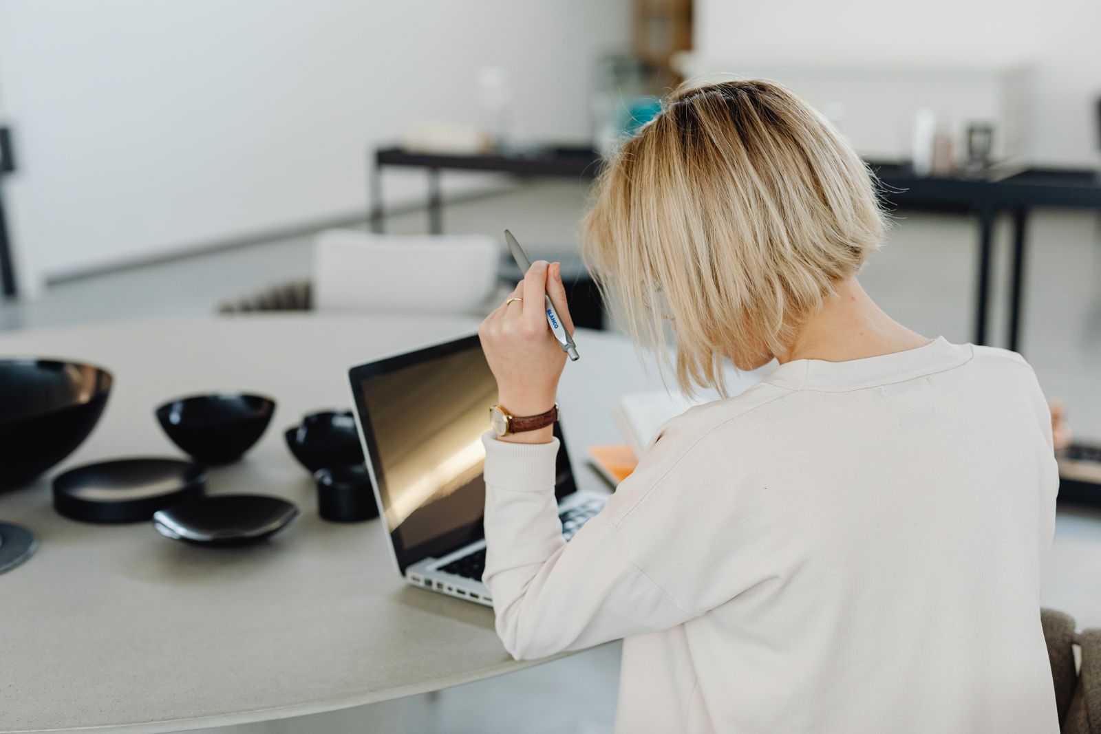 A businesswoman concentrating on her laptop in a contemporary office setting.