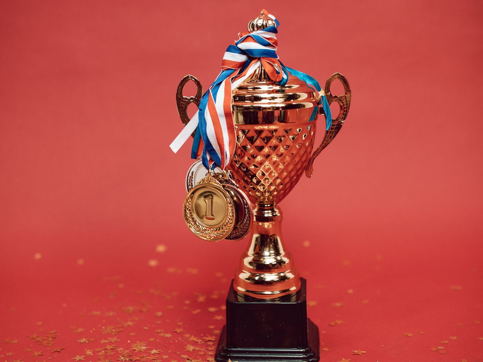 Golden trophy with medals on a red backdrop