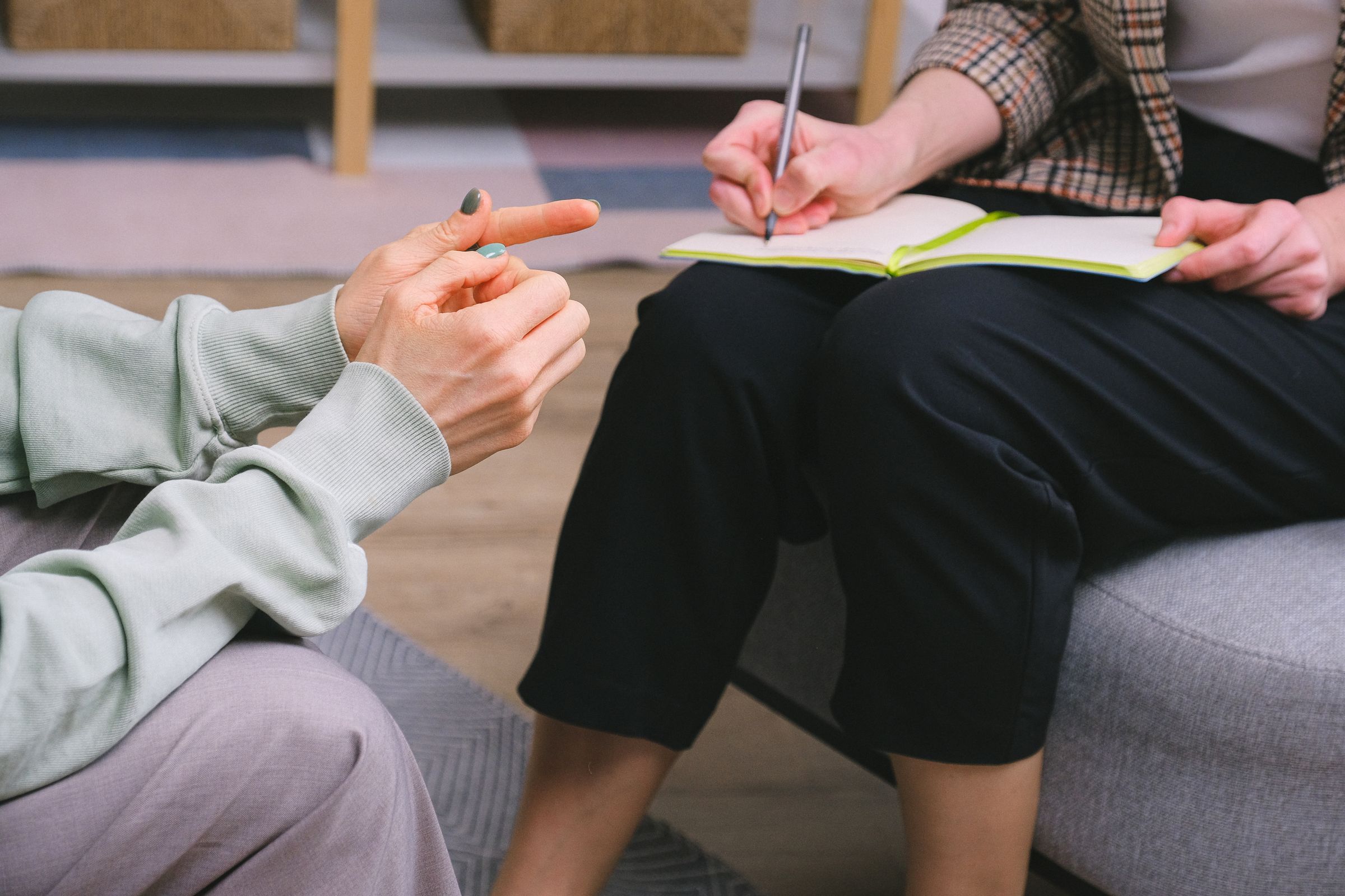 Coach taking notes in a notebook during a one-on-one coaching session