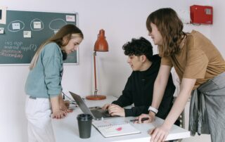 Group of young developers brainstorming ideas for a tech startup in a modern office setting.