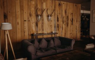 Warm and inviting living room with rustic wooden wall and cozy furniture.