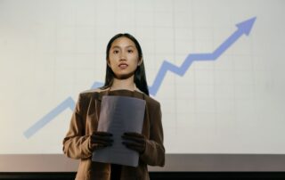 A confident businesswoman presenting a growth chart in a professional setting.