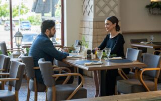 A man and woman enjoying a romantic meal in a cozy café setting, exuding warmth and connection.